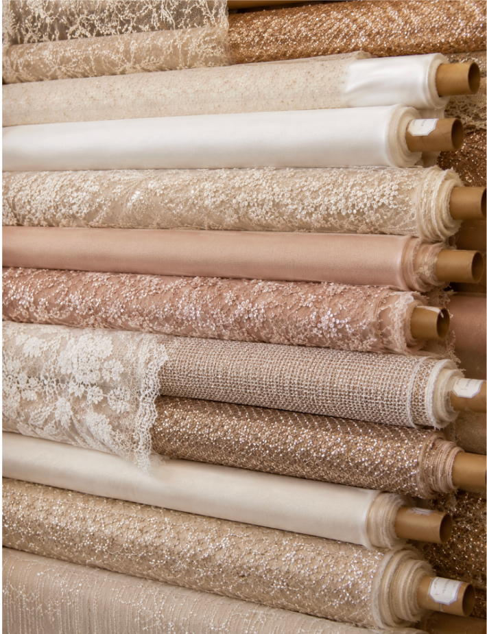 Collection of fabric rolls in various textures and colours.